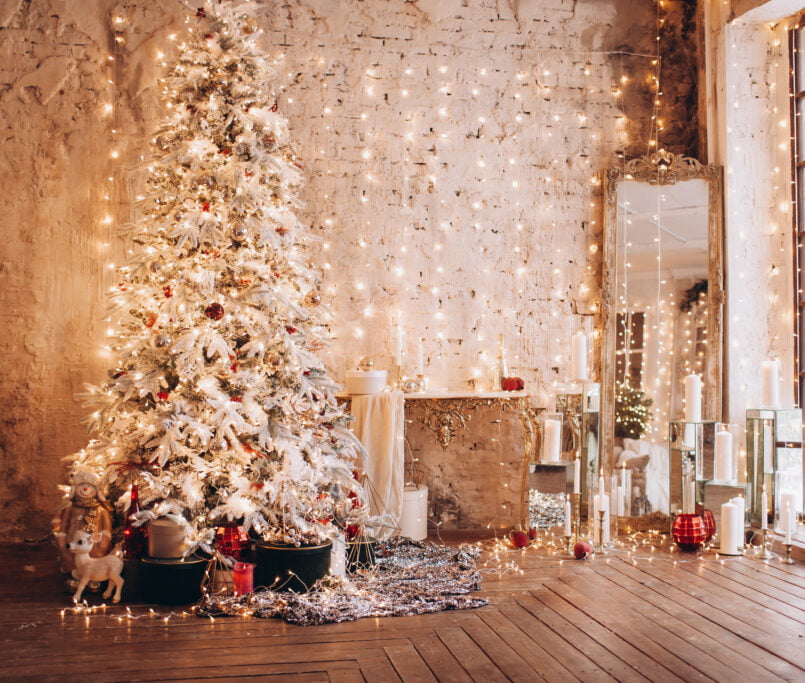 Beautiful Christmas tree and decorated living room with hardwood floors.