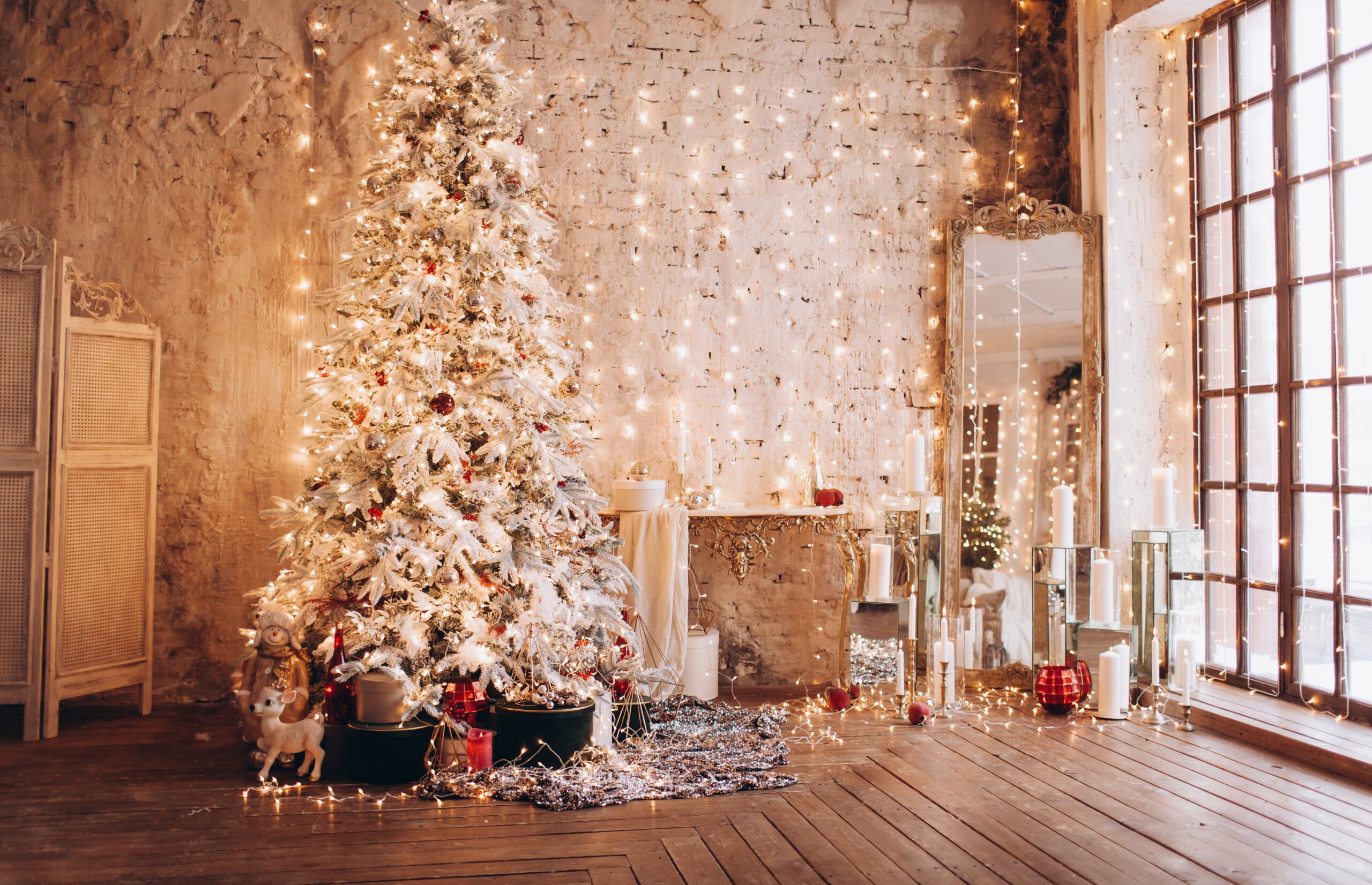 Beautiful Christmas tree and decorated living room with hardwood floors.